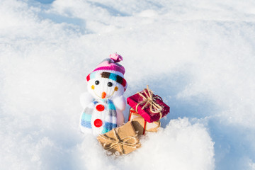 toy snowman with gifts in a snowdrift