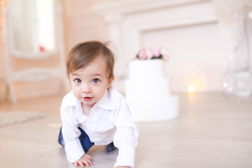 A child in a white shirt in a beautiful room in an apartment on his birthday.