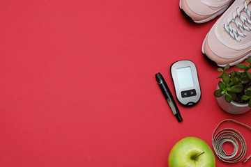 Composition with diet diabetes weight loss concept - Sneakers, tape measure, glucometer on a red...