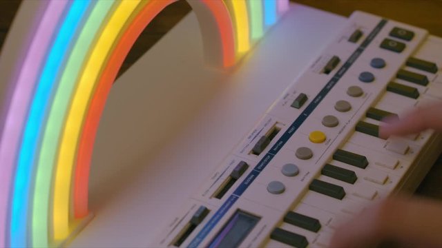 Kids hands playing keyboard with rainbow light