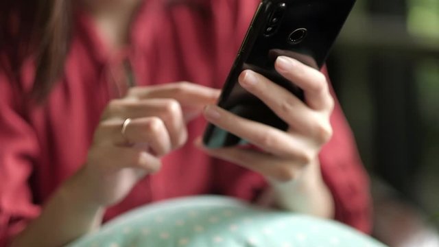 Closeup hand of woman having video call on her smartphone.