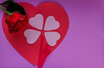 Hearts on a purple background. Fresh rose with green leaves. Valentin's Day, love. Top view. Flat lay. Greeting card.