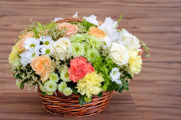 flowers in basket on wooden background