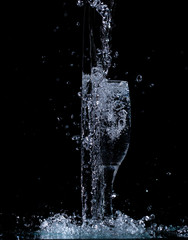 Obraz na płótnie Canvas splash and spatter of water in a wine glass on a black background