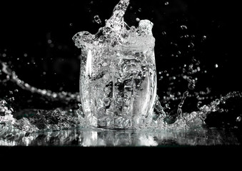splash and spatter of water in a wine glass on a black background