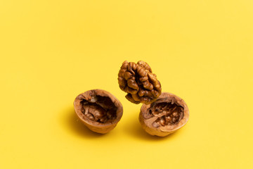 Delicious flying walnut on bright yellow background.