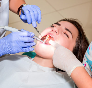 Dentist and his assistant carrying out a thorough examination (real treatment)