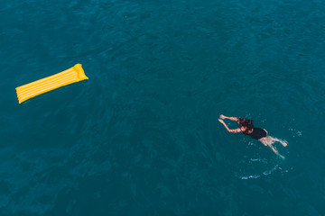 Obraz premium young woman swimming in blue azure water