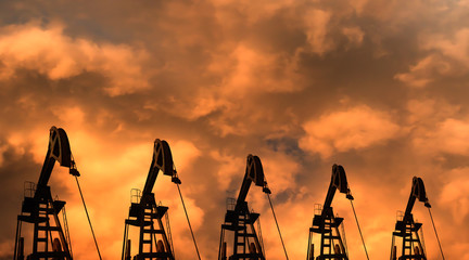 Silhouettes of oil pumps (pumpjack) at stormy sky