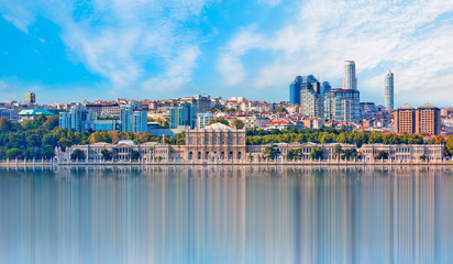 Naklejka premium Dolmabahce palace against coastal cityscape with modern buildings under cloudy sky istanbul city