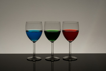 Wine glasses with different color drinks in a low light environment