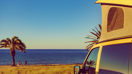 Camper van with tent on roof on beach © Voyagerix