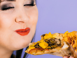 Woman eating hot pizza slice