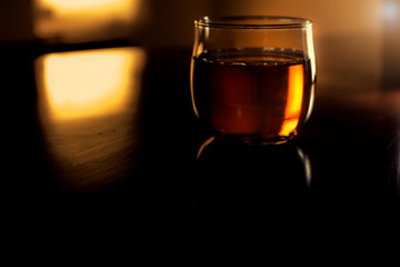 a glass of whiskey on wood bar