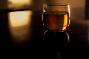 a glass of whiskey on wood bar, soft focus.