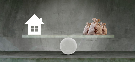 Housing loan market Sample houses and balance piggy bank on the seesaw Real estate concepts.