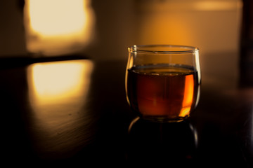 a glass of whiskey on wood bar, soft focus.