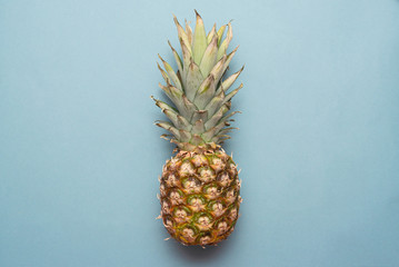 Ripe pineapple fruit on blue background flat lay.