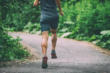 Foto auf Acrylglas Antireflex Läufer-Mann-Athlet, der in der Stadt joggt, läuft auf dem Parkweg, der Blick vom grünen Sommerwald im Freien hinter sich lässt. © Maridav