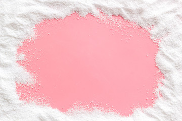 Washing powder scattered on pink background top view frame copy space