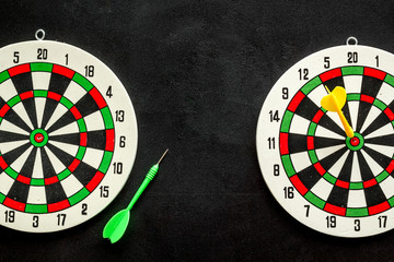 Goal achievement concept. Dartboard and arrows or dart on black background top view copy space