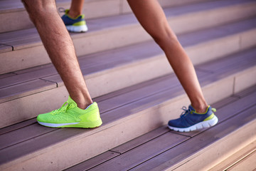 Modern woman and man exercising in urban surroundings near the river.
