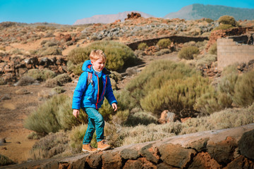 little boy with backpack hiking in mountains, child travel in Teide national park, Tenerife, Spain