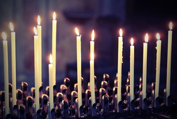 candles lit by the faithful inside a church