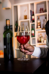 The waitress was pouring a glass of red wine. 