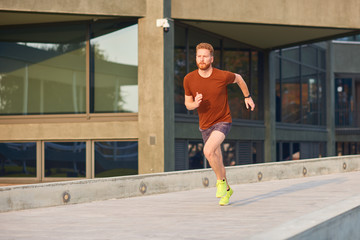 Young man exercising / running in urban park.