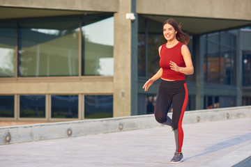 Naklejka premium Young woman exercising / running in urban park.
