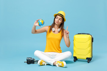 Traveler tourist woman in yellow casual clothes, hat with suitcase photo camera isolated on blue background. Female passenger traveling abroad to travel on weekends getaway. Air flight journey concept