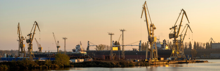 Fototapeta na wymiar Industrial landscape. Cranes and gantries in the Szczecin shipyard.Panorama.Szczecin, Poland-November 2019