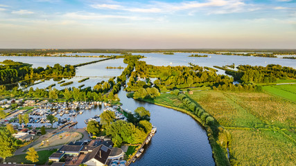 Aerial drone view of typical Dutch landscape with canals, polder water, green fields and farm...