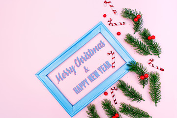 Christmas pine tree and photo frame with xmas decoration on pink background