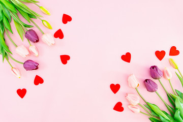 Valentine's Day composition. Tulip flowers and red hearts on pink background. Valentine's day, Mother's day concept. Flat lay, top view, copy space