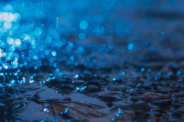 Autumn background with bokeh from the drops of rain, bright blue light is refracted through drops...