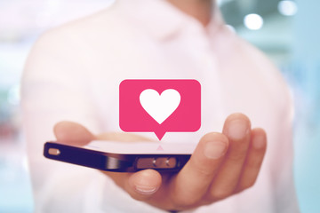スマートフォンでハートの通知マーク SNS heart on smartphone SNS app