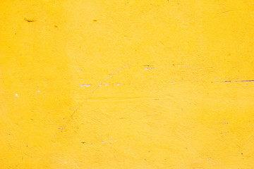 plastered old wall painted yellow textured paint with scratches and damage