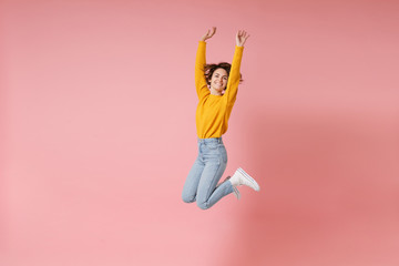 Cheerful young brunette woman girl in yellow sweater posing isolated on pastel pink background in...