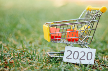 Paper shopping bags in a shopping cart on wood table, on green wall background.concept online shopping. 