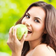 Young happy smiling lovely brunette woman with green apple