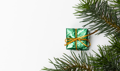 Top view of Christmas gift box red balls with spruce branches, pine cones, red berries and bell on white background.