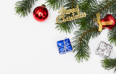 Top view of Christmas gift box red balls with spruce branches, pine cones, red berries and bell on white background.