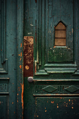 Fototapeta na wymiar Vintage weathered green wooden door with metal doorknob