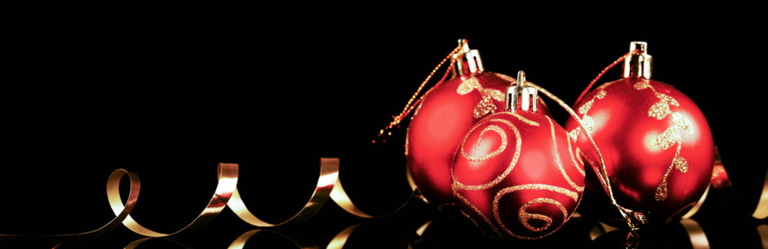 Christmas red ball with gold ribbon over black background