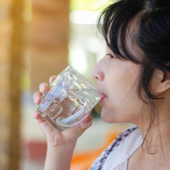 Happy woman drinking water while smiling.