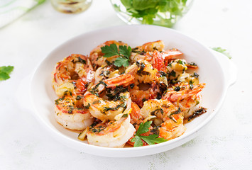 Grilled shrimps. King prawn tails in orange-garlic sauce with parsley.