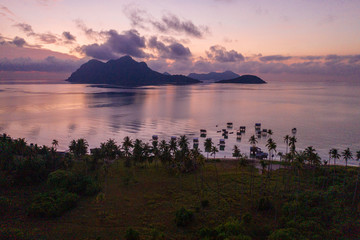 Aerial view of Sea Gypsy water village, island and the ocean with sky during sunrise in Semporna,...