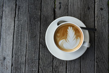 Close up a white coffee cup with heart shape on wood desk